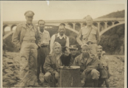 Claude M. Adams (squatting to left of cormorant) and group, posing with a cormorant diving bird used to fish, Japan, late ...