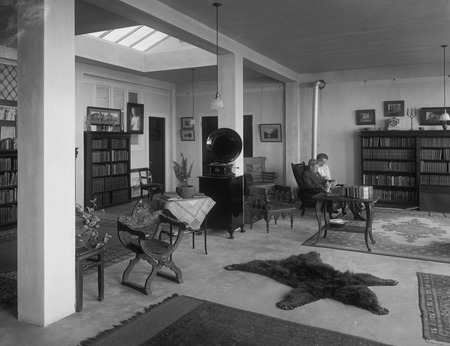 William Emerson Ritter sitting and reading and his wife Mary Bennett Ritter in their living room of their apartment, which...