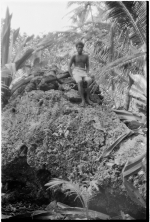 Man on shrine on top of coral outcropping