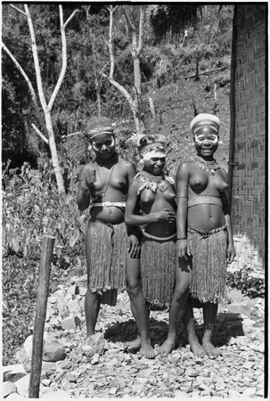 Adolescent girls (Kopi, Kanila, and Kena) smiling next to the Cooks&#39; house in Kwiop