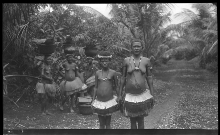 Women and girls of the Trobriand Islands, some balancing baskets on heads
