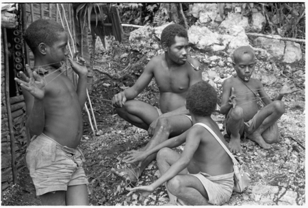 Laete&#39;eboo and his sons playing with lalefui&#39;olanga string figures in front of the men&#39;s house.
