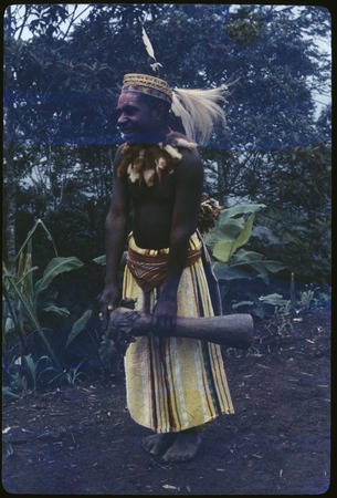 Pig festival, singsing: decorated man (Aindeim) holds small kundu drum