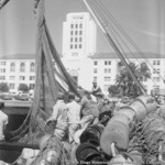 Fishing nets piled on Embarcadero near docked tuna boat Starcrest