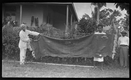 Malakai Veisamasama and European man holding very old piece of tapa cloth
