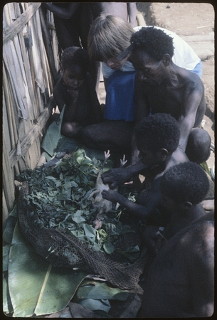 Food preparation: watched by children, Amangware and Komber, Ann Rappaport and Mer prepare chicken for cooking