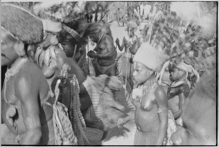Pig festival, pig sacrifice, Kompiai: man (l) in red wig, and decorated adolescent girls