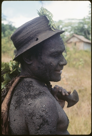 Basiitau painted black, wearing his very old cane hat.