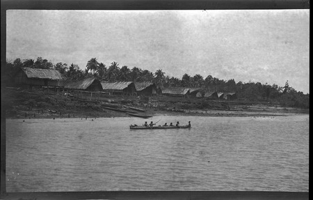 Houses near the shore, and people in a canoe