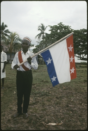 Man with Christian Fellowship Church flag, which is red, white, and blue, with white stars