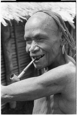 Portrait of older woman, with homemade pipe.