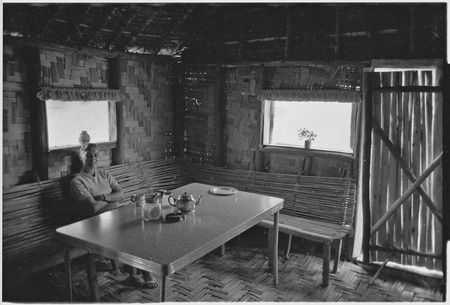 Edwin Cook&#39;s house in Kwiop: Nancy Cook sits at table