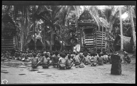 Hookworm lecture in front of yam houses, at Kiriwina Island