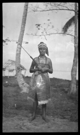 Portrait of woman in Samoan dress holding rod