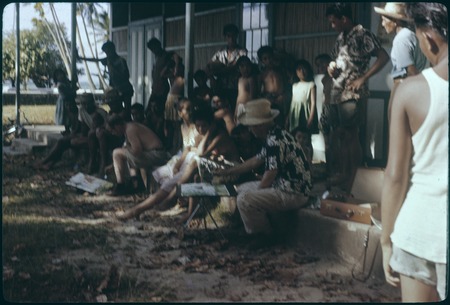 Artist on school house steps, Society Islands, surrounded by crowd