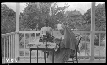 Sister Madeleine of Yule Island Catholic mission with typewriter and child