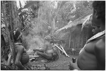 Pig festival, stake-planting, Tuguma: men build fire to cook sacrificial pig