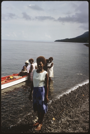 Portrait of woman. Solomon Islanders in back with canoe