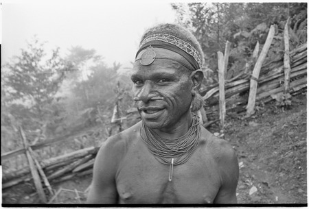 Portrait of man wearing luluai badge, marsupial fur ornaments, and nose plug