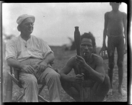 Sylvester Lambert sitting beside Solomon Islander holding club