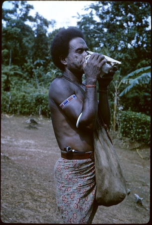 Man blowing conch.