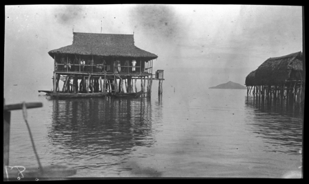 People in houses on stilts over water