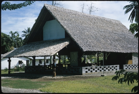 Large building with thatched roof, sculptures, Makira.
