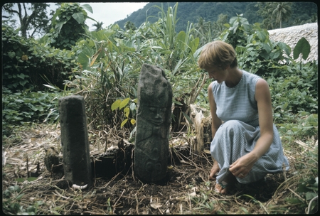 Anne Scheffler sitting beside a grave carving