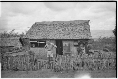 Unidentified European man in front of a house