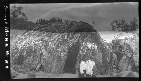 Woman and child in front of a house at Mona Mona