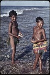 Fishing: girl holds small net on the fringing reef near Wawela