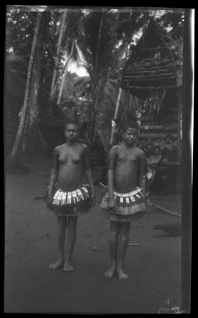 Two Trobriand girls in front of yam house