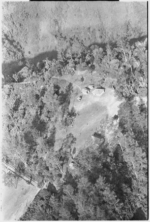 Houses in clearing, moutains: aerial view