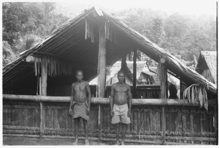 Two men in front of house.