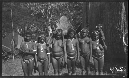 Mafulu women and girls of Deva Deva village, in mountains of Central Province, with shell jewelry; woman on left holding y...