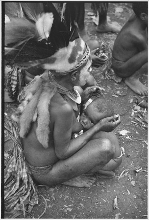 Bride price ritual: bride, wearing headdress and other finery, breastfeeds child