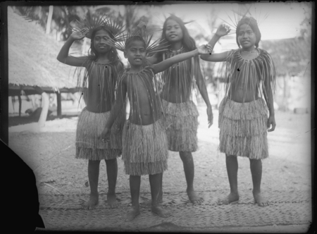 Children in grass skirts, and shoulder and head pieces