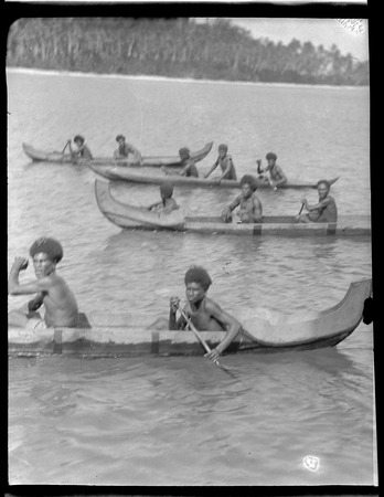 Several men rowing canoes