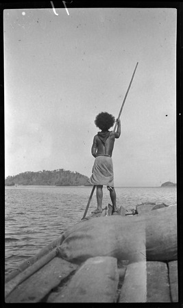 Man poles canoe, near Port Moresby