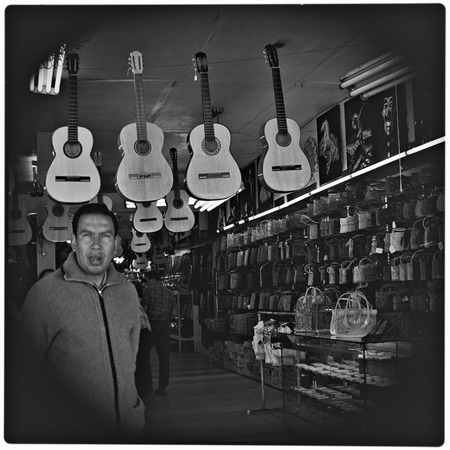 Shopkeeper and guitars in curio shop