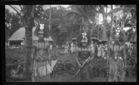 Portrait of two men and a women, wearing traditional Samoan headdress and ornaments