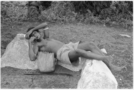 Man resting by stone.