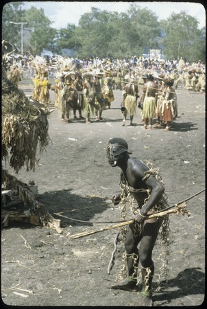 Port Moresby show: dancers, man in foreground with blackened skin, mask, bow and arrows