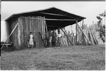 Wanuma: people by lumber shed, Lutheran mission buildings