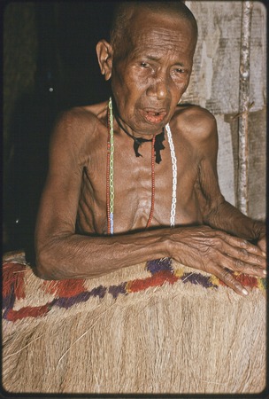 Weaving: Bomtavau, her head shaved in mourning, displays long skirt made of banana leaf fibers