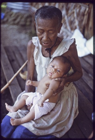 Bomtavau holds young infant, probably a grandchild