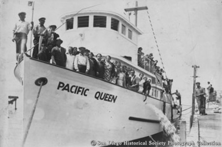 Men and women on deck of docked tuna boat Pacific Queen