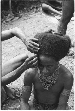 Pig festival, wig ritual, Tsembaga: man&#39;s hair is pulled over wig frame