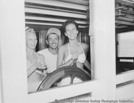 Man with two women at wheel of tuna boat