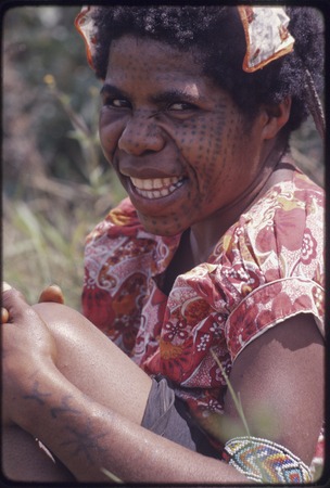 Western Highlands: smiling woman with tattoos on face and arm
